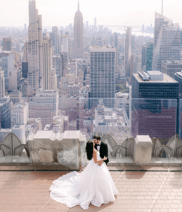 A bride and groom embrace on a New York City rooftop overlooking the skyline, captured in a cinematic moment perfect for immersive ReLOOM VR storytelling.